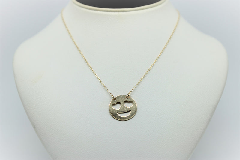 Gold chain with a smiling emoji pendant